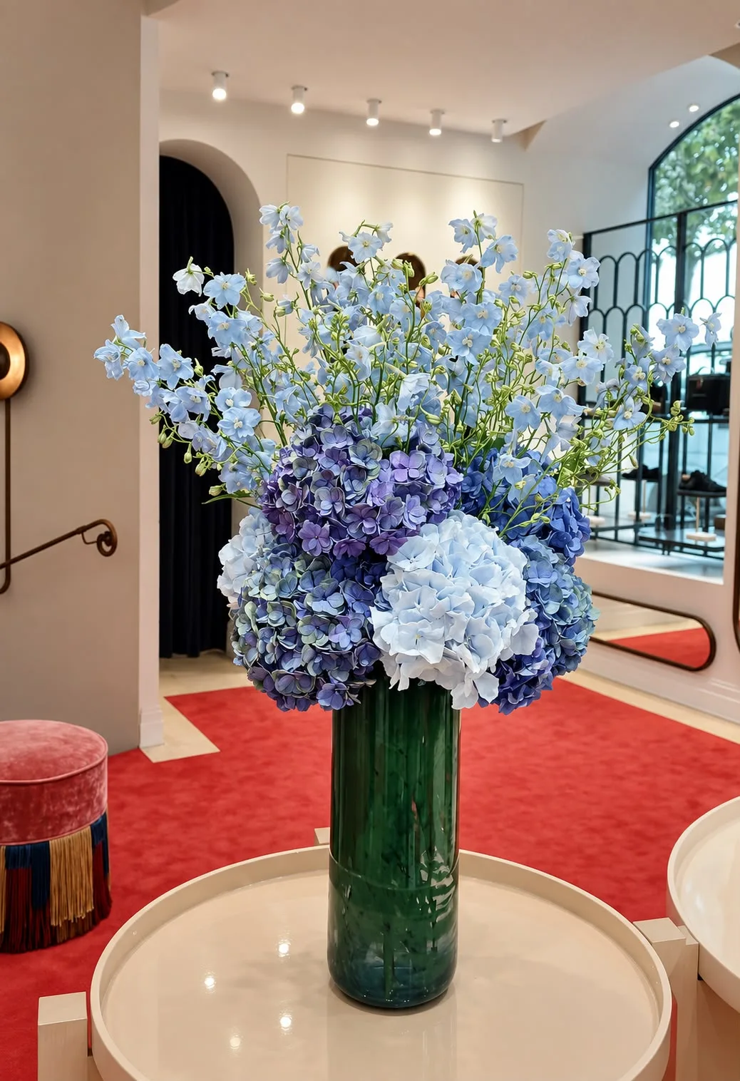 Hortensias et delphiniums dans un grand vase vert